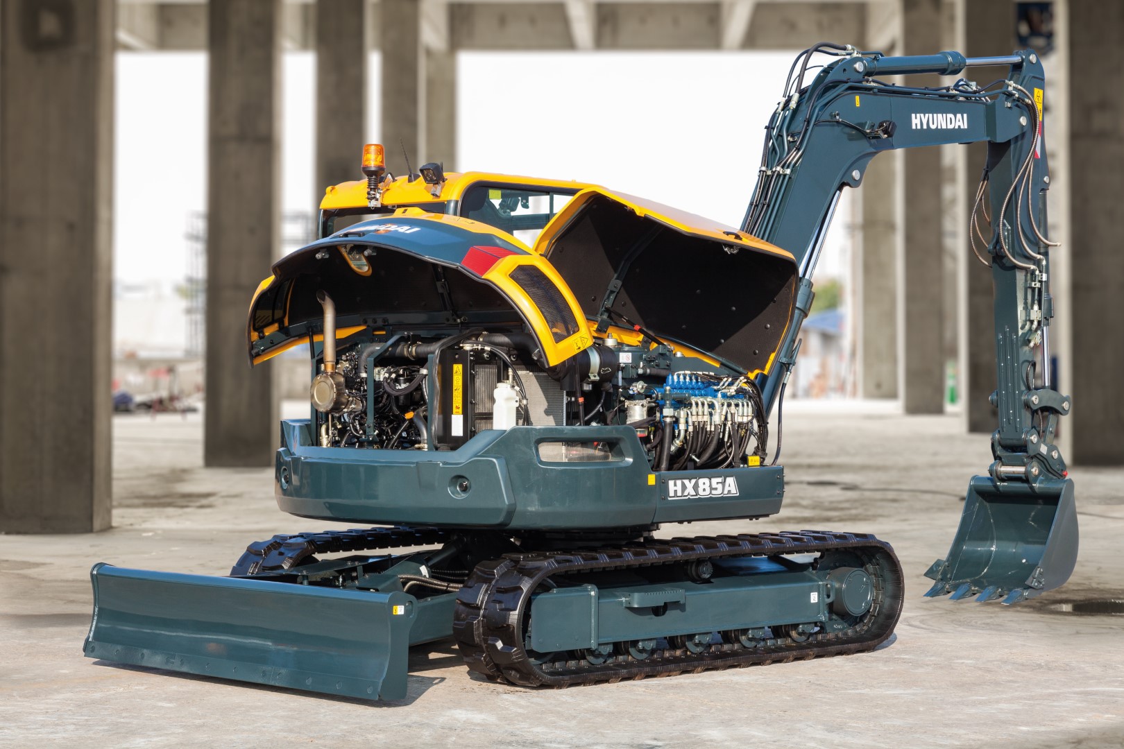 De HX85A compacte graafmachine maakt deel uit van de gloednieuwe A-serie van Hyundai: een nieuwe generatie bouwmachines die voldoet aan de Europese emissiestandaard Euro V. Maar hij heeft nog veel meer in petto! Terwijl aan de regelgeving is voldaan, streeft Hyundai naar een baanbrekend niveau in klanttevredenheid met maximale prestaties en productiviteit, meer veiligheid, meer gemak en een verbeterd uptimemanagement. Deze compact nieuwkomer in de power utility-klasse combineert een robuuste constructie met een uitstekende stabiliteit. Zeer veelzijdig en uitgerust met nieuwe elementen, creëert hij een wereld aan nieuwe mogelijkheden waarin kleine inspanningen bergen verzetten. Het is tijd om het Hyundai-effect te ervaren!