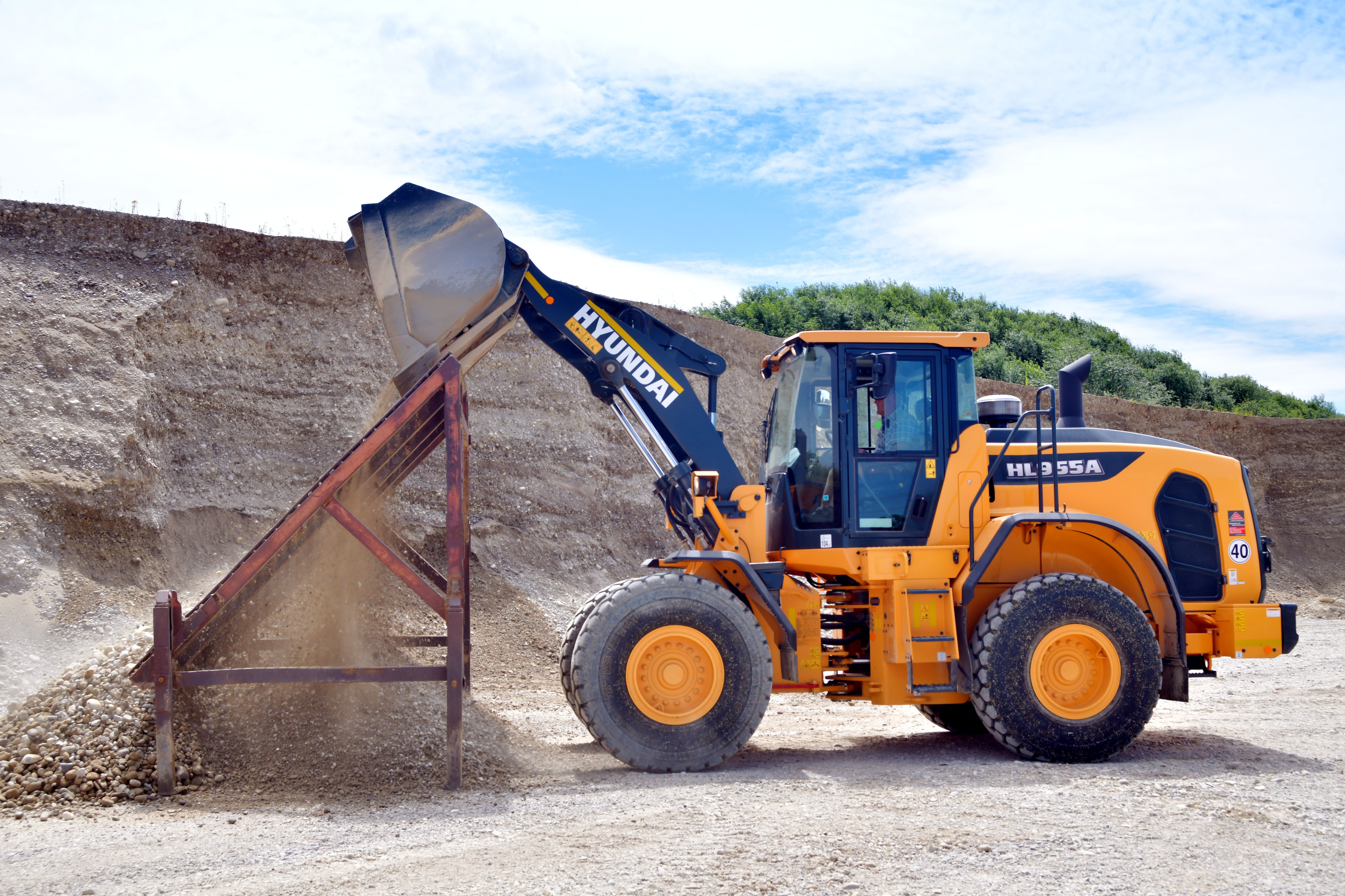 HYUNDAI HL955A WIELLADER Details kunnen een enorm verschil betekenen als het gaat om veiligheid, met name wanneer u onder zware omstandigheden werkt. Het draait niet enkel om het naleven van regels. De veiligheidsfuncties van de HL955A zijn ontworpen en getest om aan uw behoeften in de echte wereld te voldoen, en u beschikt zelfs over een extra paar ogen dankzij het optionele, geavanceerde rondomzichtsysteem (AAVM) en het intelligente detectiesysteem voor bewegende objecten (IMOD) en radarsystemen. Het vertrouwen wordt gesterkt door technieken die een gevoel van stabiliteit en soepele prestaties bieden bij zwaarbelast werk. Doordat deze wiellader voor een rustige, ongevalvrije werkplek zorgt, verhoogt hij de productiviteit en de gemoedsrust van elke machinist.