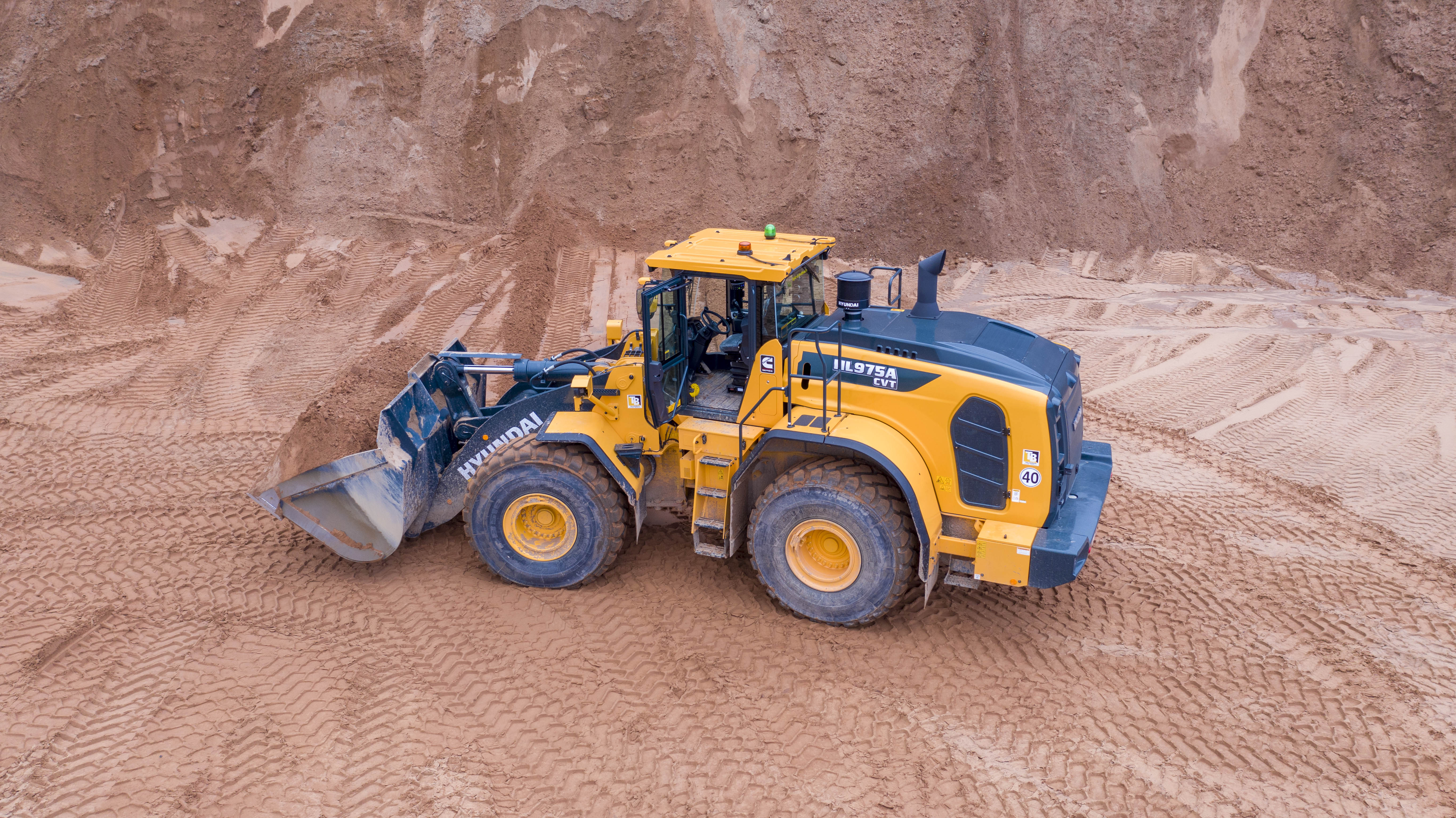 De geavanceerde CVT-transmissie van ZF zorgt voor een geoptimaliseerde vermogensaanpassing, past continu de verhoudingen tussen hydraulische en mechanische energie aan (op basis van belasting en snelheid) om de motor in een laag toerentalbereik te houden en levert een soepele, naadloze acceleratie. Tijdens het vertragen werkt de CVT tevens als rem, waardoor de bedrijfsrem minder snel slijt en de levensduur van de asolie wordt verlengd. Met een reeks nieuwe, elektronisch geregelde bedieningsstanden kan de operator de prestaties van de machine exact afstemmen voor maximale efficiëntie tijdens elke taak. Nauwkeurige besturingssystemen helpen u het maximale uit deze krachtige machine te halen, inclusief een geoptimaliseerde vermogensaanpassing voor de ultieme balans tussen koppel en toerental. In vergelijking met de conventionele transmissie kan het Powerline-concept brandstofbesparingen tot 30% realiseren, afhankelijk van de toepassing, en biedt het daarnaast soepele prestaties tijdens zwaar belaste werkzaamheden zoals graven. De eigen weegsysteemtechnologie van Hyundai is standaard geïntegreerd. Met behulp van de extra bedienings-, bewakings- en onderhoudsfuncties kunt u de prestaties en productiviteit elke dag optimaliseren, op elke werklocatie.