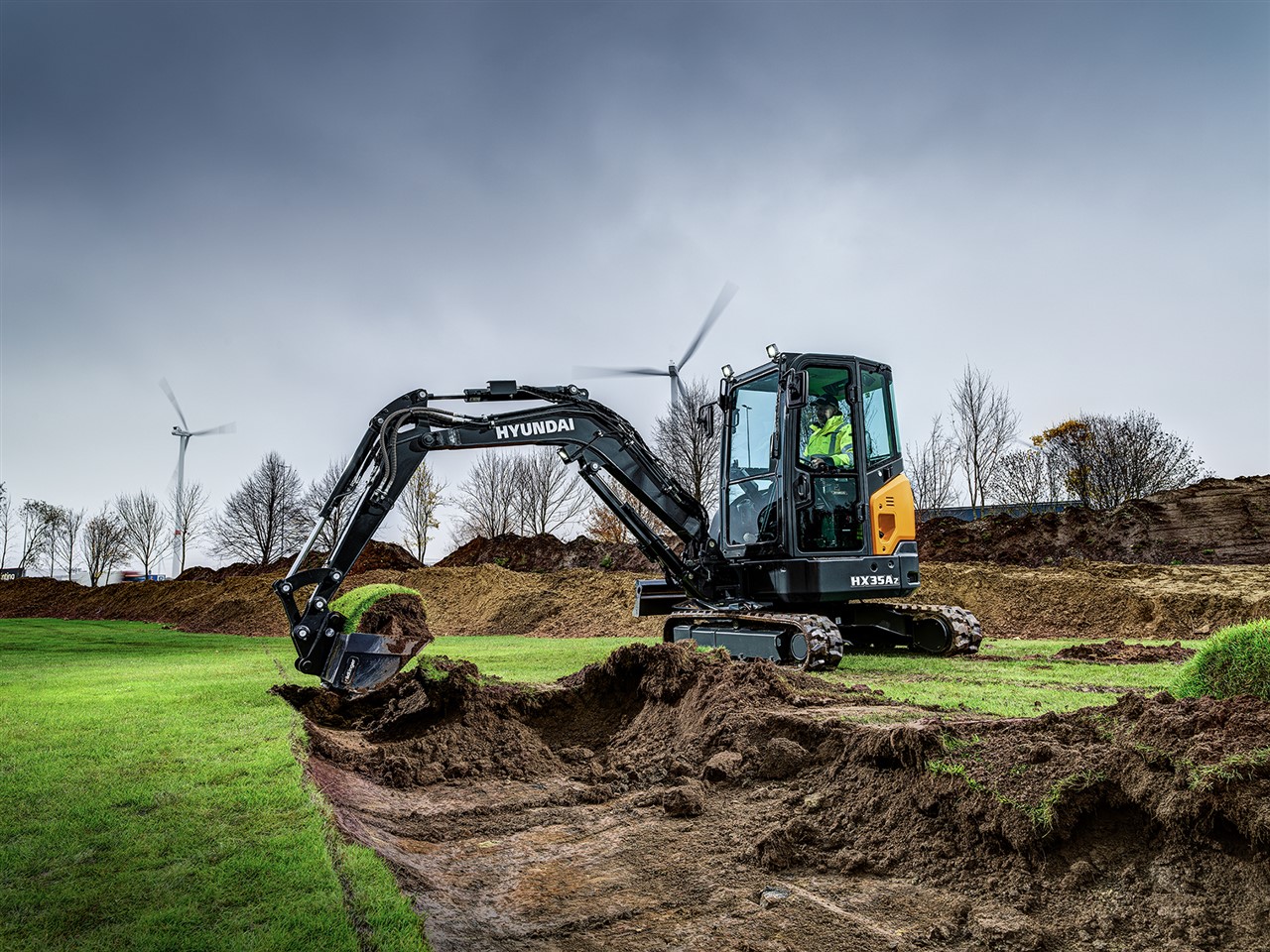De cabine van de HX35A Z is ontworpen om elke operator een productieve en stressvrije werkomgeving aan te bieden. Zijn ergonomische ontwerp helpt u gemakkelijker en met minder vermoeidheid te presteren. Bedieningshendels zijn gemakkelijk bereikbaar en een instrumentendisplay is beschikbaar voor de operator zodat die geïnformeerd is over relevante machinegegevens.